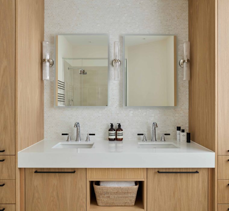A bespoke oak double vanity unit with tall storage cupboards in the main bathroom of a Richmond Riverside apartment crafted by Origins Design. Bespoke Furniture Maker London